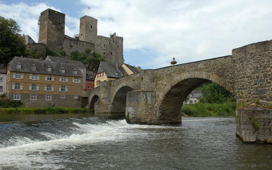 The Lahn River flows under the 15th-century stone bridge with Runkel Castle towering over the village of Runkel.