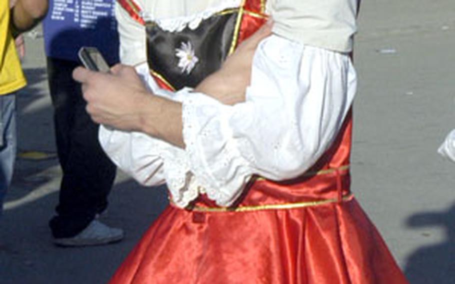 A young man dressed in a dirndl stumbles around the festival grounds. While thousands of women don the traditional German dress for Oktoberfest, most men wear lederhosen.