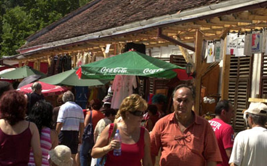 Tourists walk past stalls selling Romanian crafts and dozens of Dracula-themed souvenier near Bran Castle.