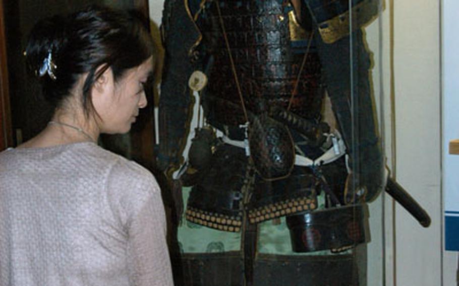 A Japanese tourist checks out a suit of Samurai body armor inside Matsumoto Castle.