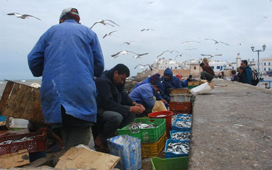 Men clean sardines and other fish near the docks in Essaouira, a fishing port on the Atlantic coast of Morocco.