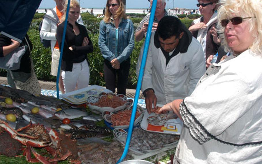 A woman orders some fish from one of the seaside vendors in Essaouira. Essaouira is about 80 miles north of Agadir.