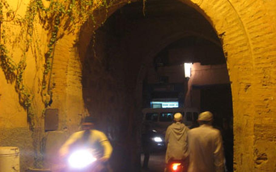 Traveling at night aboard a scooter through the medina of Marrakech, Morocco, is a fascinating way to blend into the local crowd.