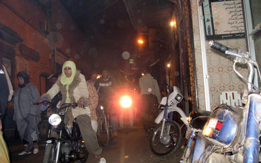 Scooter riders navigate the narrow streets of the old city in Marrakech. It&#39;s not unusual to find scooter-riders pushing their way through people inside the crowded souks with its hundreds of shops and stalls.