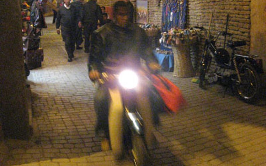 Traveling at night aboard a scooter through the medina of Marrakech, Morocco, is a different way to get some sightseeing done.