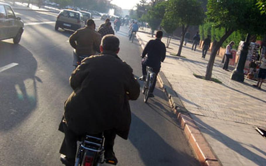 Motor scooters of different shapes and sizes make their way down Avenue Mohammed VI during a sunny spring day in Marrakech.