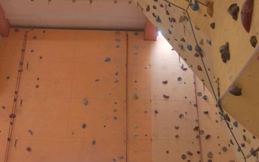 Göritz reaches a tricky part of the climbing wall. Some of Camp 4’s more difficult climbs project from the wall so that climbers’ backs are nearly parallel to the floor.