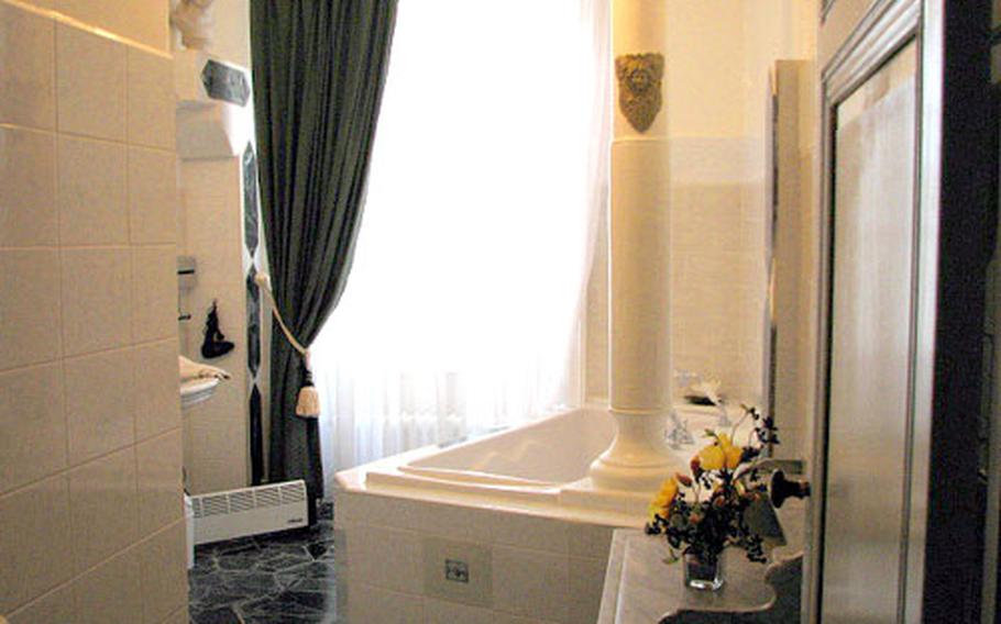 This elegant marble bathroom at Chateau de la Chapelle des Bois, gleaming from top to bottom, is fit for royalty.