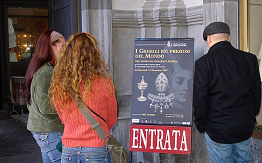 Three American visitors prepare to visit the special exhibit of the treasures of San Gennaro on display in a building attached to the cathedral in downtown Naples.