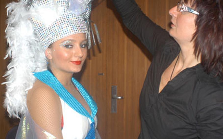 Christine Lahnstein, trainer for the Red and White Sparkles, adjusts the headgear of dancer Svetlana Stieglitz.