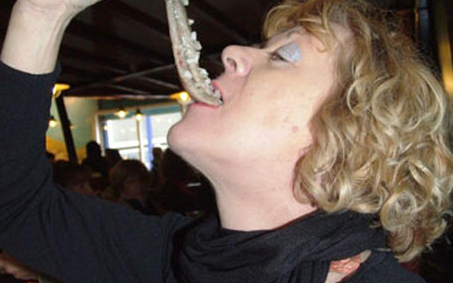 A woman at the Simonis Restaurant in Scheveningen, Netherlands, demonstrates the art of eating herring: pop the whole fish into your mouth, chew and swallow.