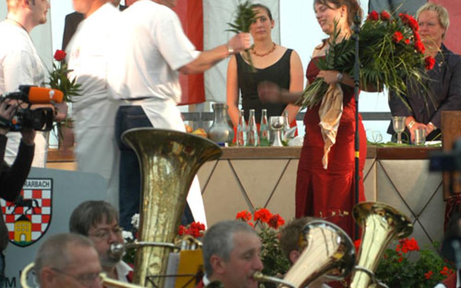 While the band plays, wine queen Julia I receives a rose from each of her admirers — apparently several, judging by the size of the bouquet in her arms.
