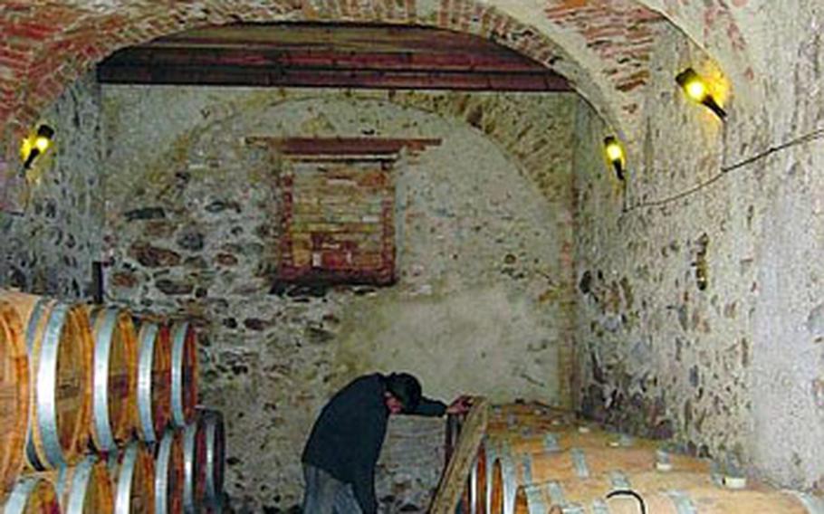 A worker at the Il Mosnel cantina worker draws wine from oak barrels for testing. The cantina, located in Italy&#39;s Franciacorta wine-growing region, opened in 1836.
