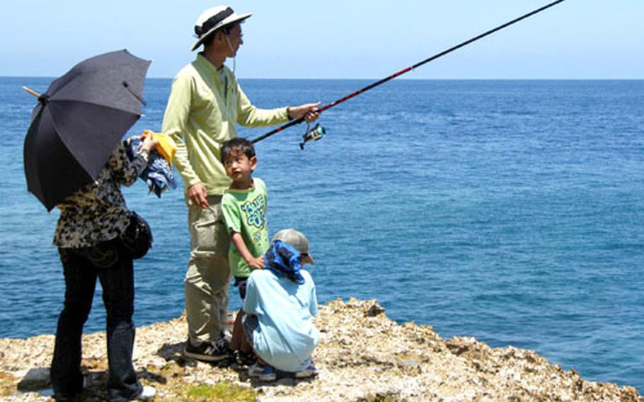 A family fishes from atop a cliff during the last day of the island’s lily festival.