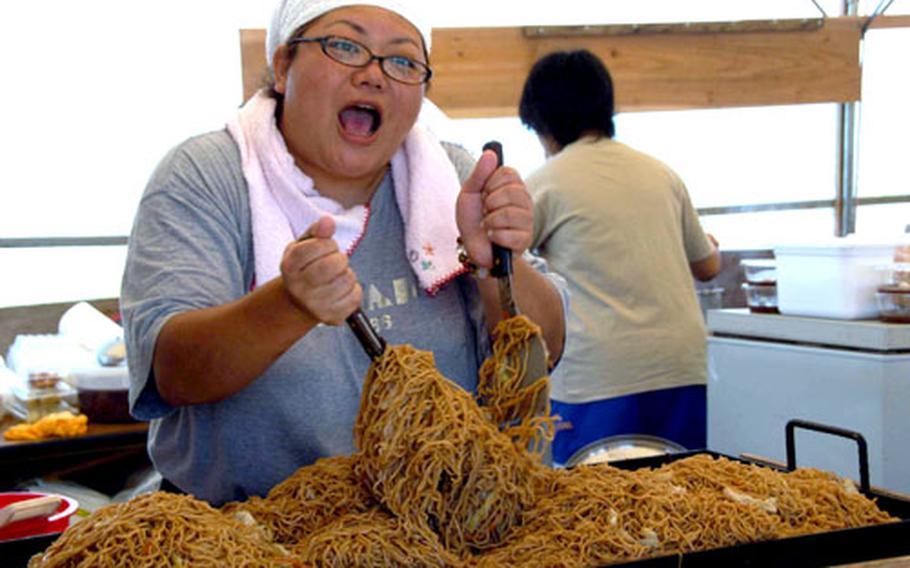 Time to eat: a woman stirs up a batch of yakisoba noodles. The dish was one of dozens for sale at the various food booths.