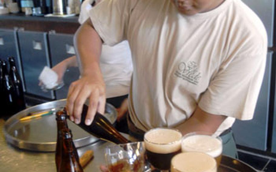Ade Rhoma Prasasti, a waiter at the In de Vrede cafe in Westvlet–eren, Belgium, pours a Saint Sixtus 12 for waiting customers. The 12 is considered by some enthusiasts the best beer in the world.