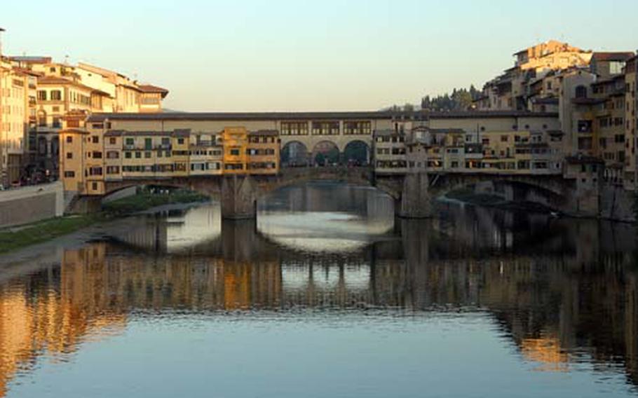 An evening view of he Ponte Vecchio, or Old Bridge in Florence. Spanning the Arno River, it was built in 1345 and is today lined with jewelry shops.