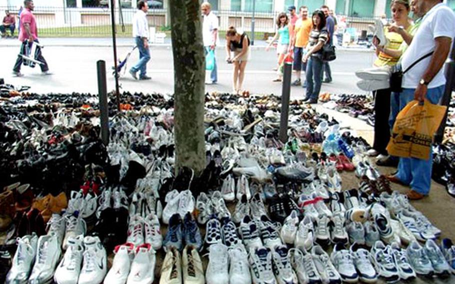 Shoes for sale surround a tree at a flea market in Frankfurt, Germany.