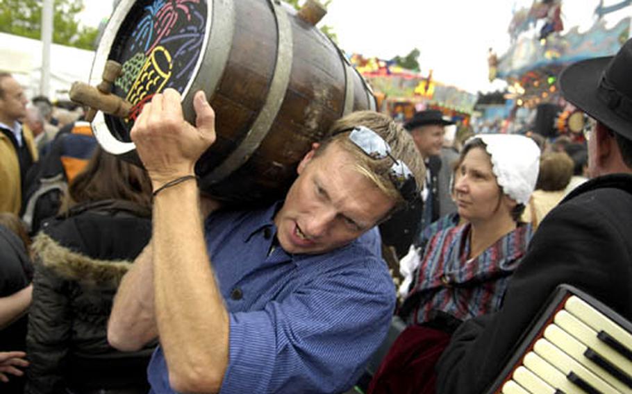 A festival worker caries the official wine barrel through the crowd Friday during the kick-off of Bad Durkheim’s legendary Wurstmarkt (Sausage Market). Vier Jahreszeiten, the largest co-op of vineyards in the area, is used as the official wine for the opening ceremonies.