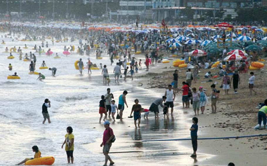 Busan&#39;s popular Haeundae beach is packed with visitors well into the evening on a hot, humid summer day.