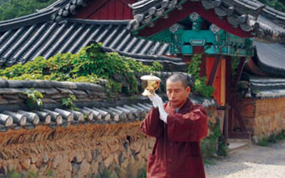A Buddhist monk at prays as he walks at Beomeosa temple, located in the mountains on the outskirts of Busan.