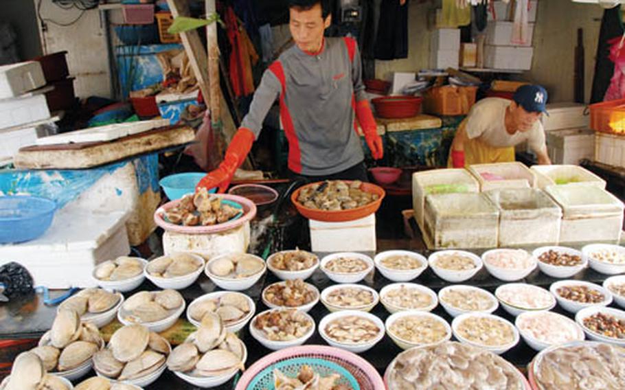 A seafood vendor arranges his at an outdoor market at Busan&#39;s Jagalchi fish market, the largest in the country.