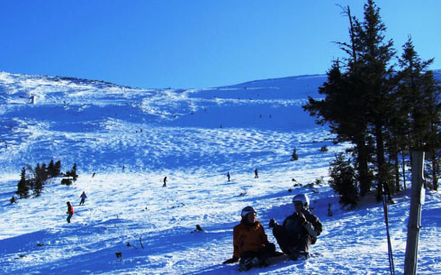 Skiers take a break for photos on the wide open slopes in Jasná.