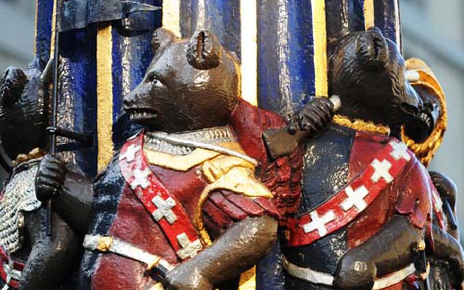 A band of bears in Swiss uniforms march around the column of the famous “Kindlifresser” fountain.