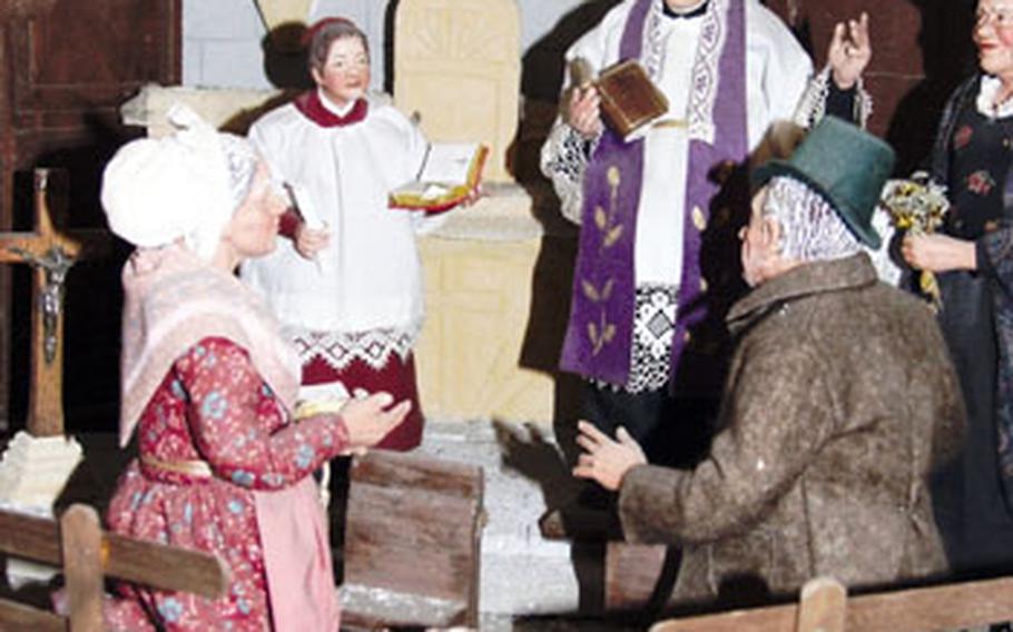 A jovial priest and some worshippers gather for a church service in this scene from the Santon Museum.