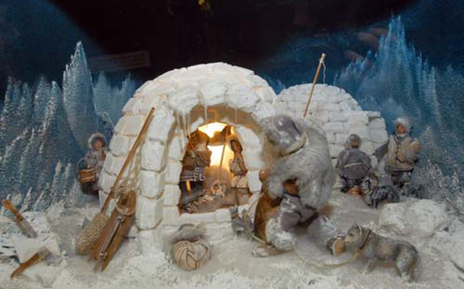 In this Alaskan nativity scene, an Inuit offers the gift of fresh fish to the Christ child. The igloo is made from cotton.
