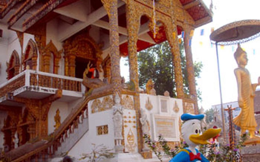 A statue of Donald Duck eating noodles stands guard in front of Wat Buppharam, a Buddhist temple, in Chiang Mai.