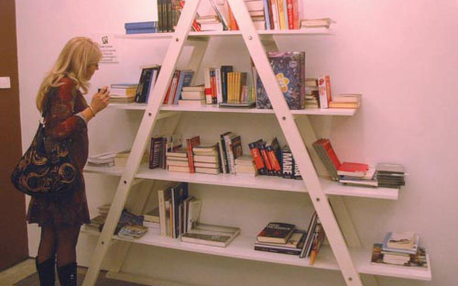 A patron scans shelved books at the Trip multi-functional cultural center in Naples, a place dedicated to exposing patrons to various art forms, from music, artwork, theater, cinematography an literature.