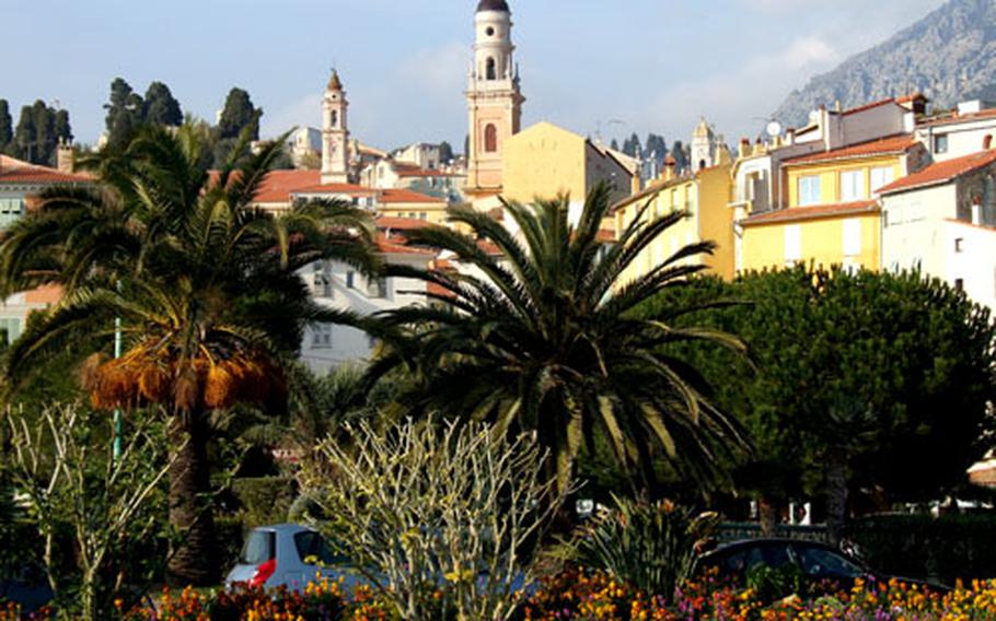 The bell tower of the baroque Saint Michael basilica juts above the rooftops in Menton, France, a city of palms and flowers and the annual lemon festival.