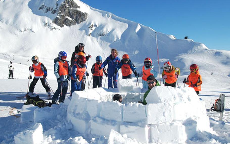 Skiers watch as a worker with the Academia Alpina builds an igloos near Piancavallo, Italy. There are currently approximately a dozen igloos on the site, about a 20-minute drive from Aviano Air Base.