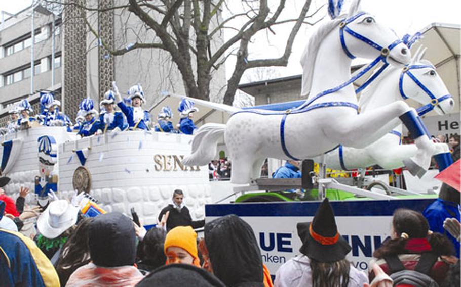 Participants riding one of the many floats throw goodies to visitors. More than 100 tons of candy are passed out during the parade.