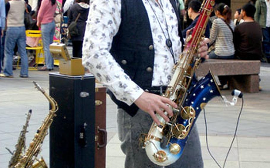 There’s entertainment outside the Taipei 101 skyscraper, including this street musician who serenaded Sunday afternoon crowds.