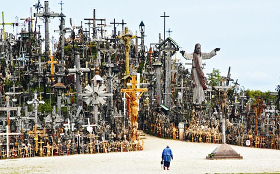 A woman is dwarfed by the Hill of Crosses. No one is certain how many crosses have been left at the site during the past years, but there are believed to be at least 50,000.