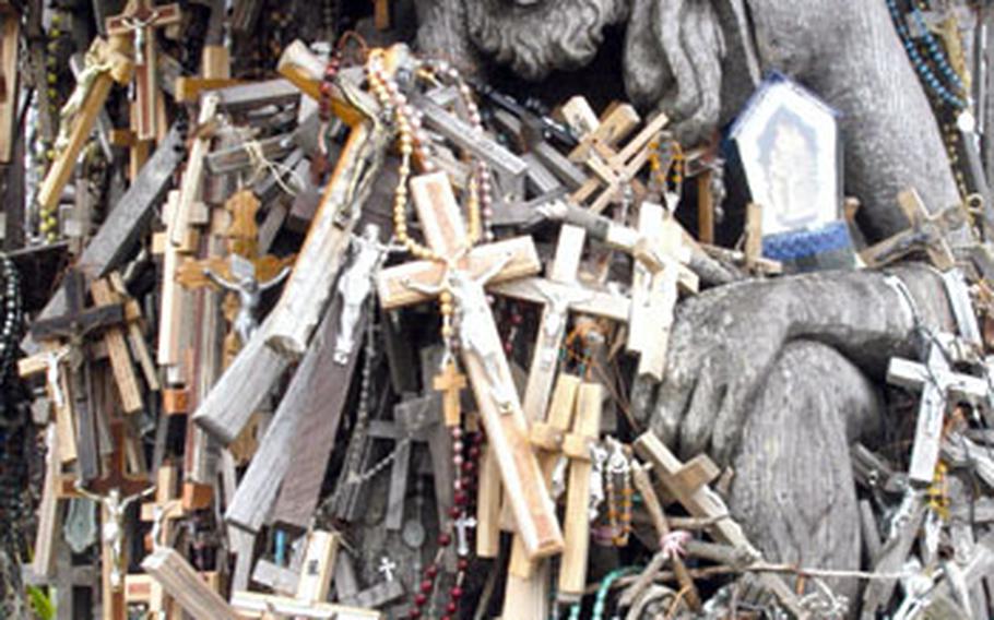 A statue of Jesus is nearly covered by crosses left by visitors to the Hill of Crosses in Siauliai, Lithuania.