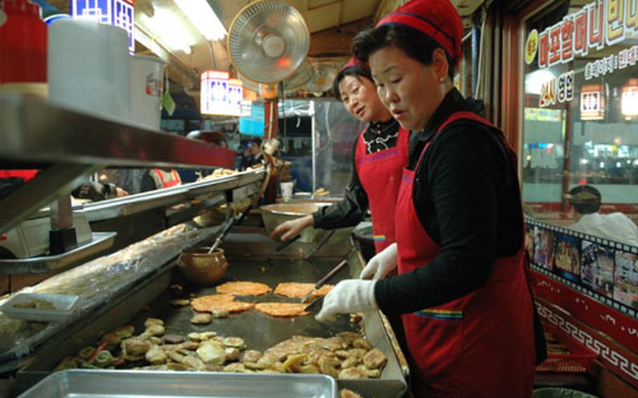 The pancakes are fried to order just outside the dining room. Here, the cooks are making jeon with red pepper paste, which goes well with beer or dong dong ju, a traditional Korean rice wine.