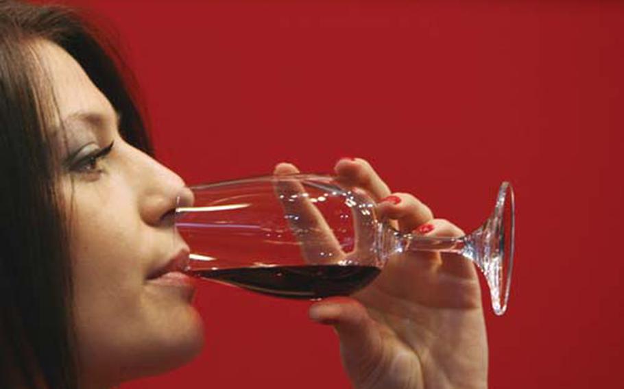 A woman tastes red wine during the annual "Vinaria 2009" international wine fair in the town of Plovdiv east of the Bulgarian capital Sofia, Wednesday, March, 18, 2009.