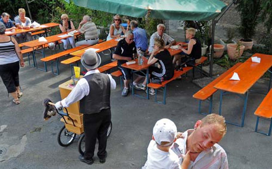 An organ grinder entertains customers in the back yard of Marcus Allendorff’s winery in Wicker, Germany.