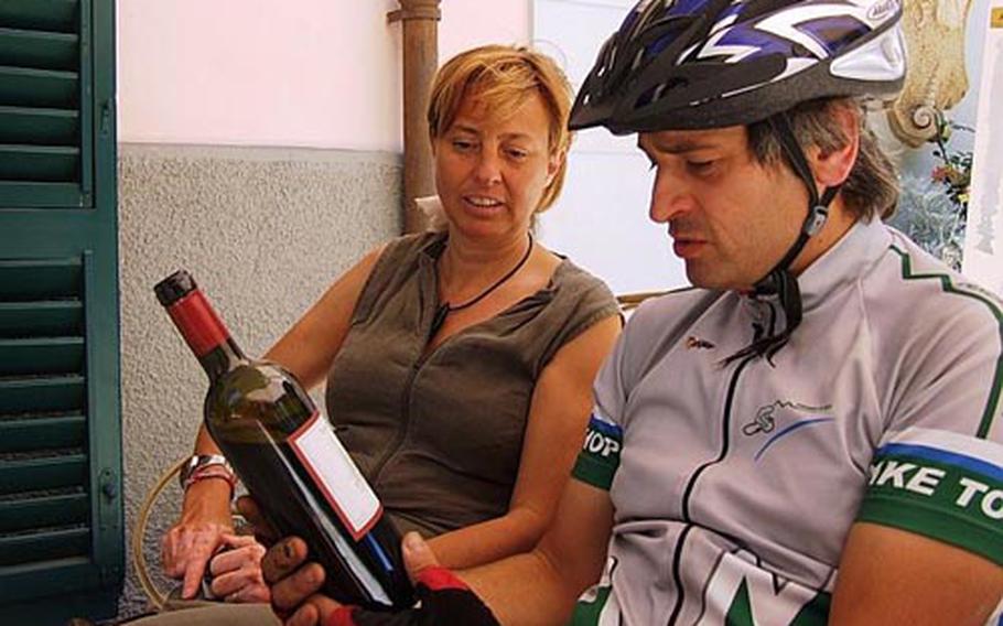 Riccardo Baldanzi checks out a bottle of wine at Tenuta del Fontino, a wine estate owned by Heidi Puntscher, left. The estate, which is also a bed-and-breakfast, has vineyards that produce about 50,000 bottles of wine every year.
