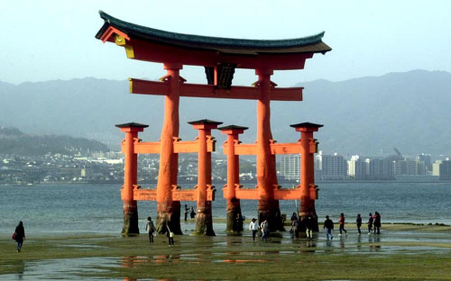At low tide, visitors to Miyajima can walk right up to, even touch, Itsukushima Shrine&#39;s famous torii gate. The shrine is a UNESCO World Heritage Site.