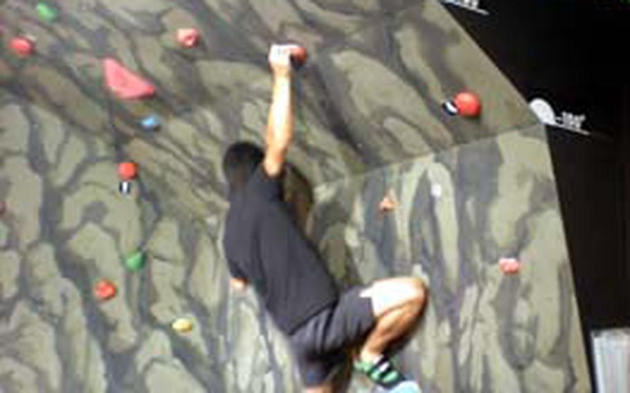 At Muscle Park in Odaiba, a man races to climb to and then press numbered buttons in a limited amount of time. Muscle Park offered several athletic venues as well as games that challenged the mind.