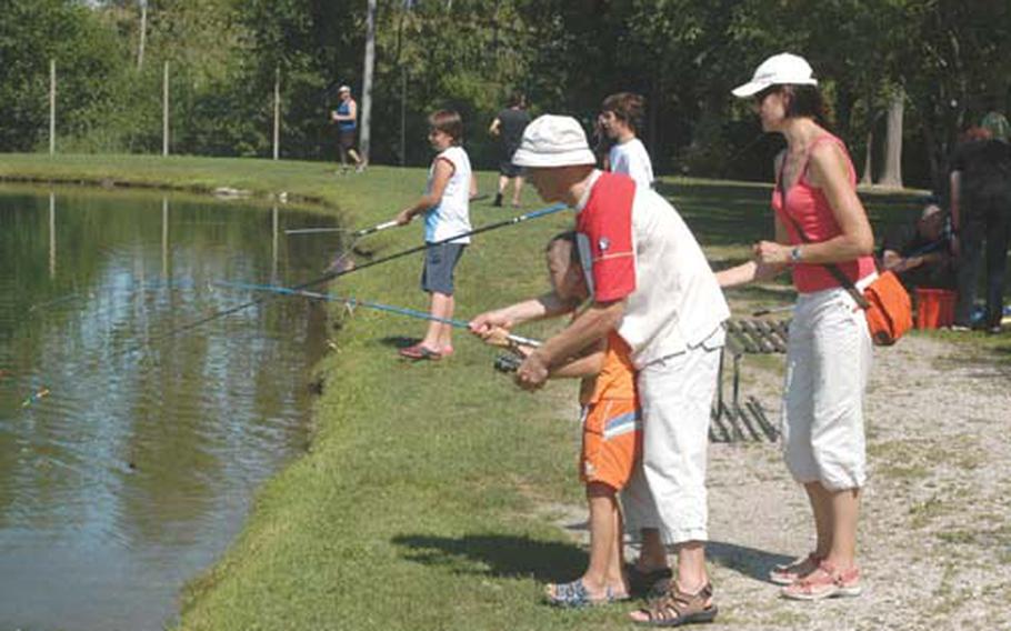 Tizziano Rosada helps his oldest son, Nicolo, reel in a fish at Lago Orzaie while mom Simona stands ready to assist.