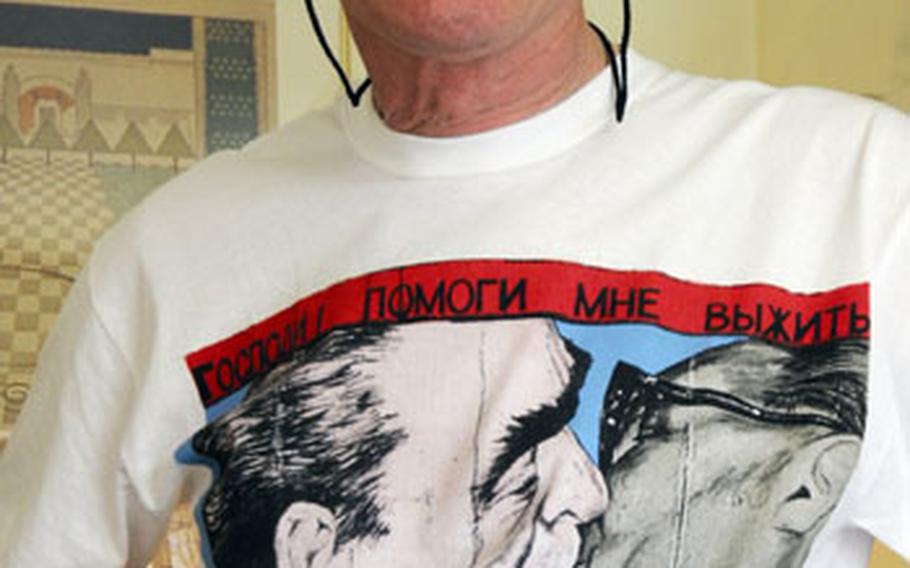 French photographer Régis Bossu proudly wears a T-shirt showing the painting based on his photograph. The shirt was sold at Berlin souvenir shops.