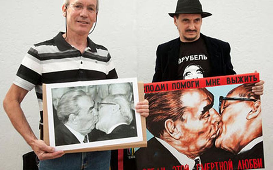 Bossu, left, and Russian artist Dimitri Vrubel meet in in front of the East Side Gallery. Bossu holds a copy of his photo while Vrubel has a copy of the painting based on the photo.