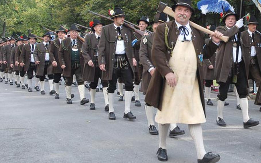 Men in Bavarian costumes carry weapons in last year’s parade.