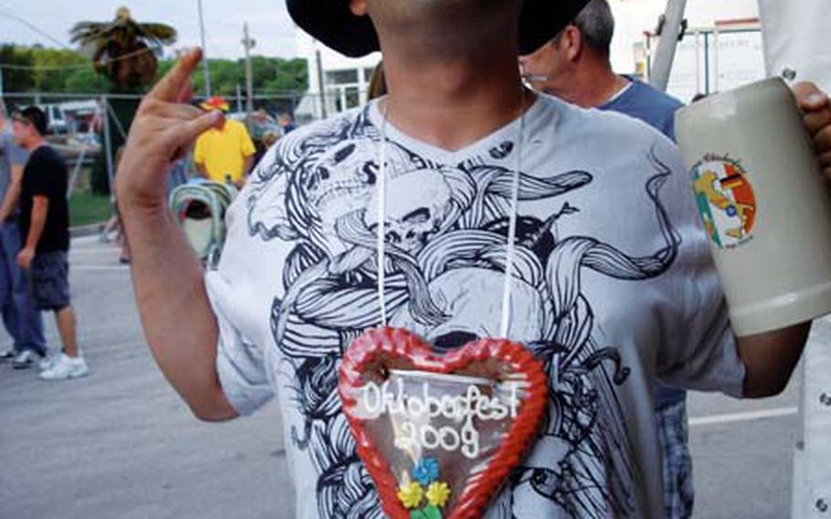 Navy Petty Officer 2nd Class Danny Pittman, gingerbread heart around his neck, Bavarian hat on his head and a mug in his hand, enjoys the celebration on the NATO base in downtown Naples.