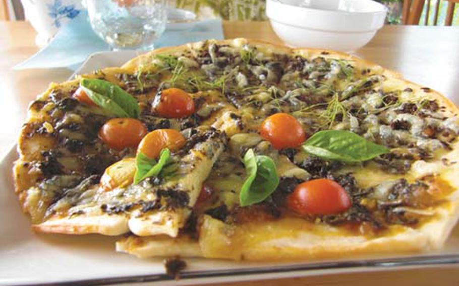 Fresh dill, basil and tomatoes garnish a pizza at the coffee shop. More than 200 kinds of herbs are grown at the farm’s herb garden.